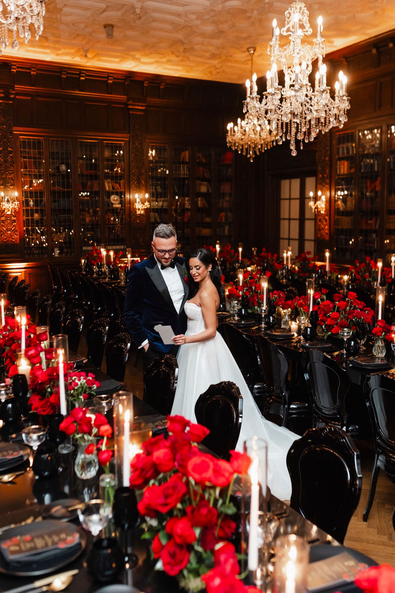 A couple surrounded by red roses and candlelight in Casa Loma's library in Toronto