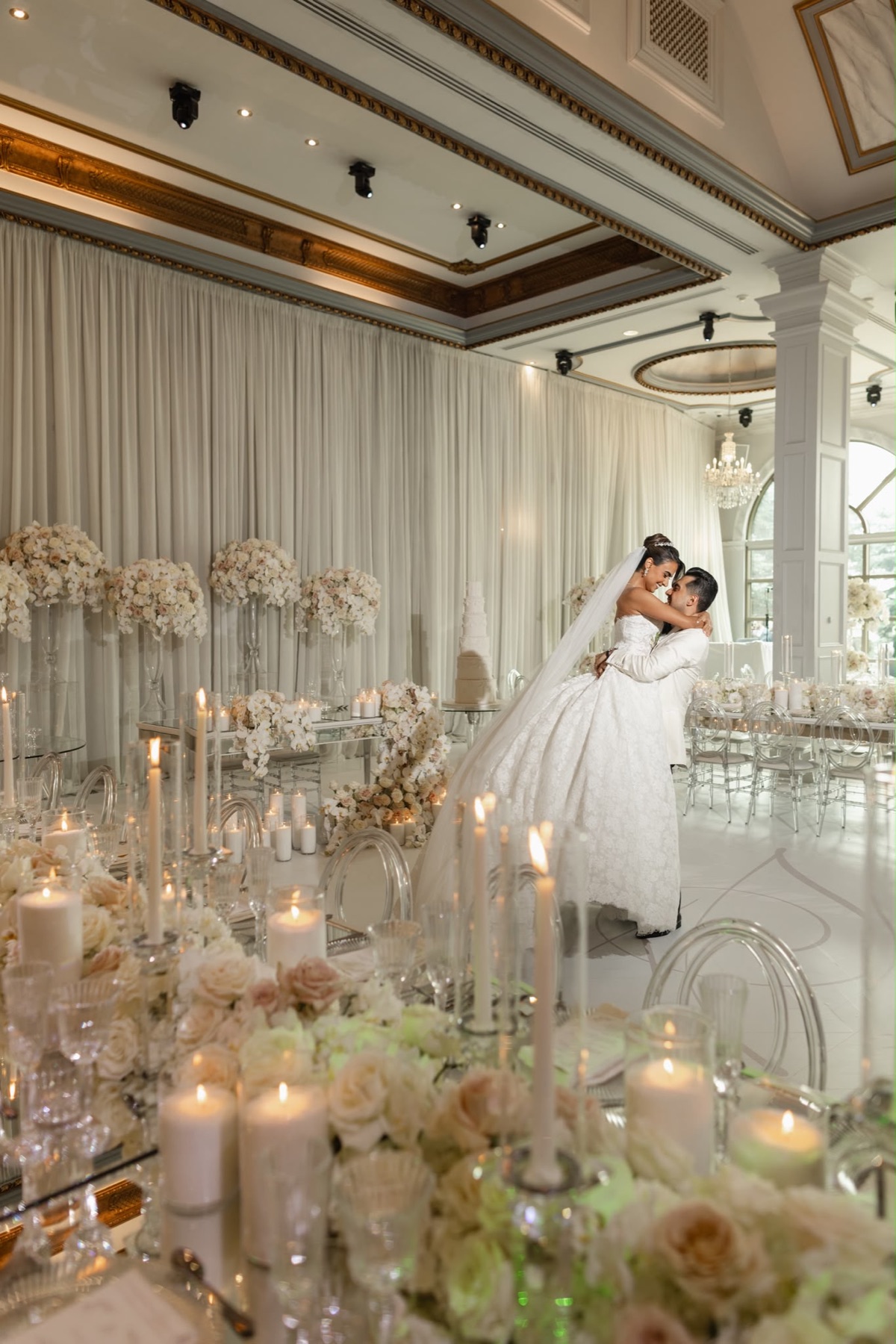 A couple dancing in a luminous blush and white reception